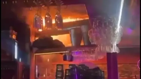 Del video që shfaq një person teksa përpiqet të shuajë flakët në momentet e para të zjarrit në Zvicër